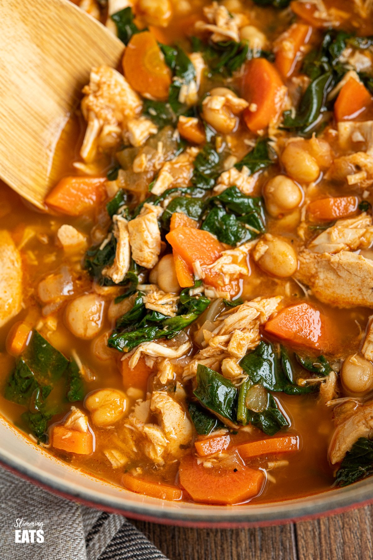 close up of chicken chickpea spinach soup in cast iron pot