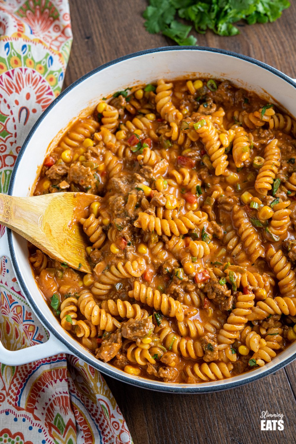 One Pot Taco Beef Pasta - an easy yummy recipe that is cooked all in one pan. Cheesy spicy taco flavoured deliciousness!! #slimmingeats #weightwatchers #onepot #beef #pasta #taco One Pot Taco Beef Pasta in skillet with wooden spoon