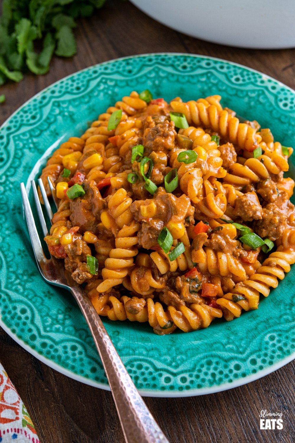 One Pot Taco Beef Pasta - an easy yummy recipe that is cooked all in one pan. Cheesy spicy taco flavoured deliciousness!! #slimmingeats #weightwatchers #onepot #beef #pasta #taco teal plate with serving of one pot taco beef pasta