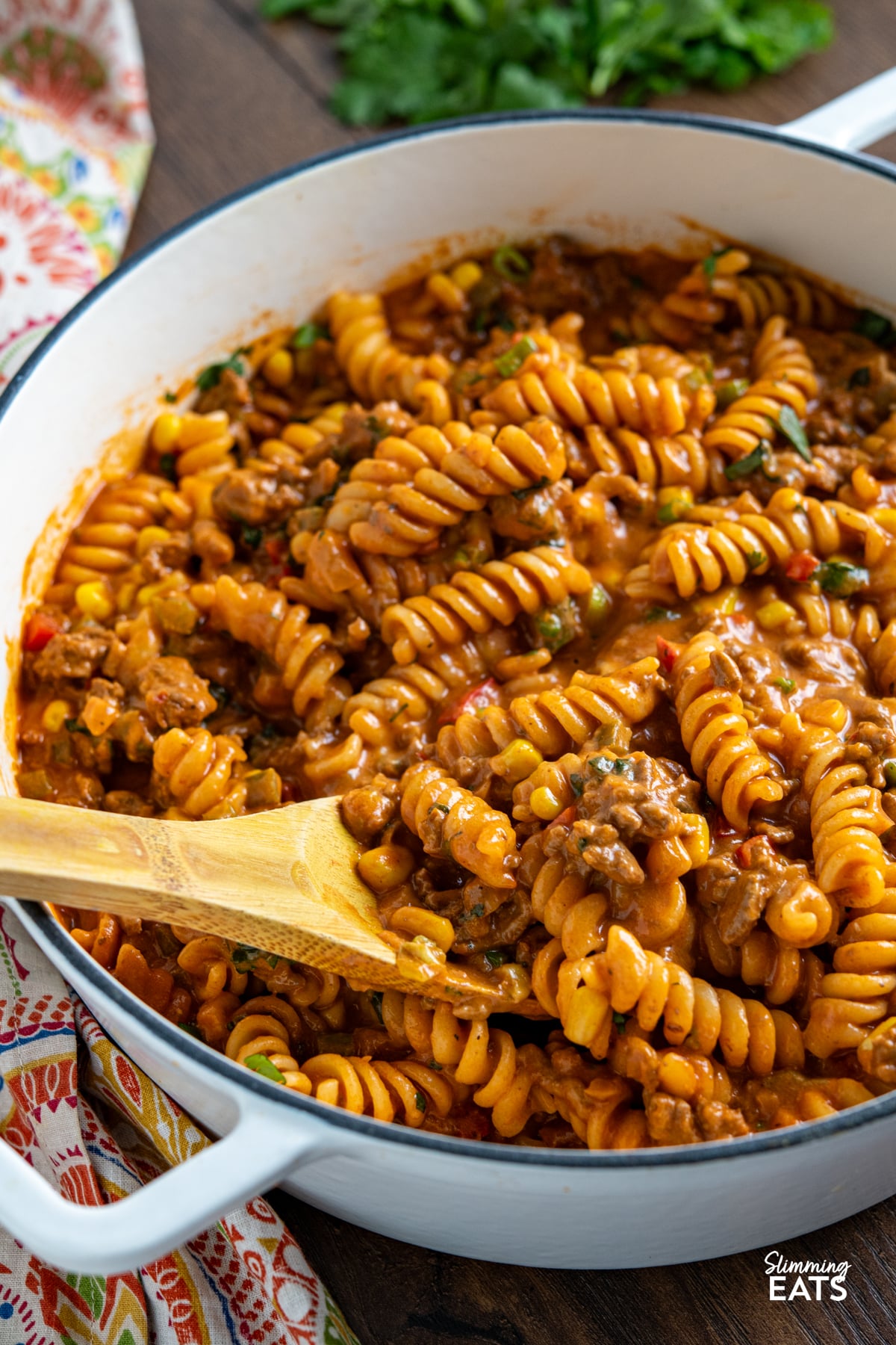 One Pot Taco Beef Pasta - an easy yummy recipe that is cooked all in one pan. Cheesy spicy taco flavoured deliciousness!! #slimmingeats #weightwatchers #onepot #beef #pasta #taco One Pot Taco Beef Pasta in skillet with wooden spoon