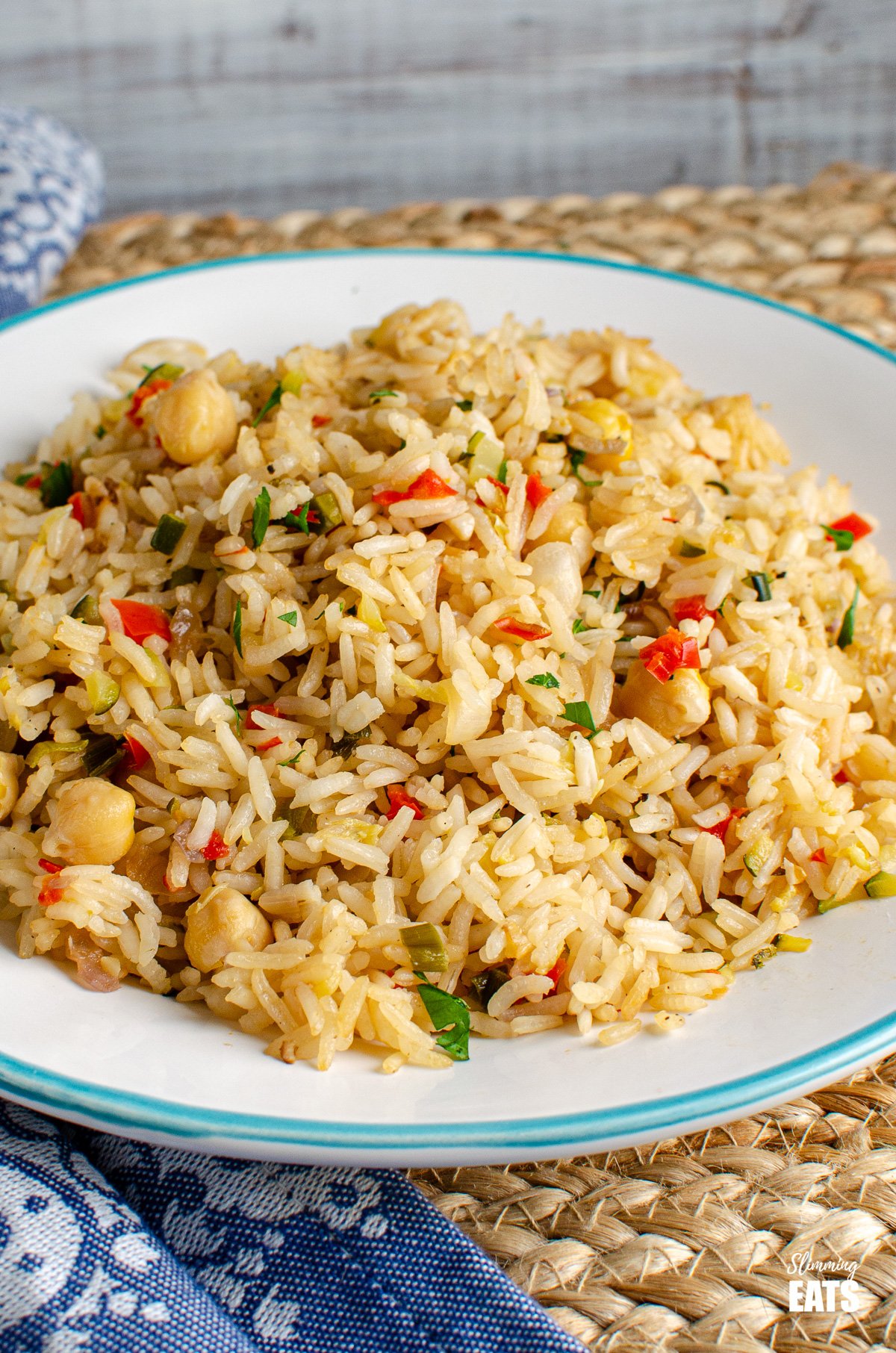 Chickpea Vegetable Rice Pilaf (from www.slimmngeats.com) - A perfect simple side dish for when you fancy something a bit more flavourful than plain steamed rice. #glutenfree #rice #dairyfree #pilaf #chickpeas #slimmingeats #weightwatchers Chickpea Vegetable Rice Pilaf on white plate with blue rim
