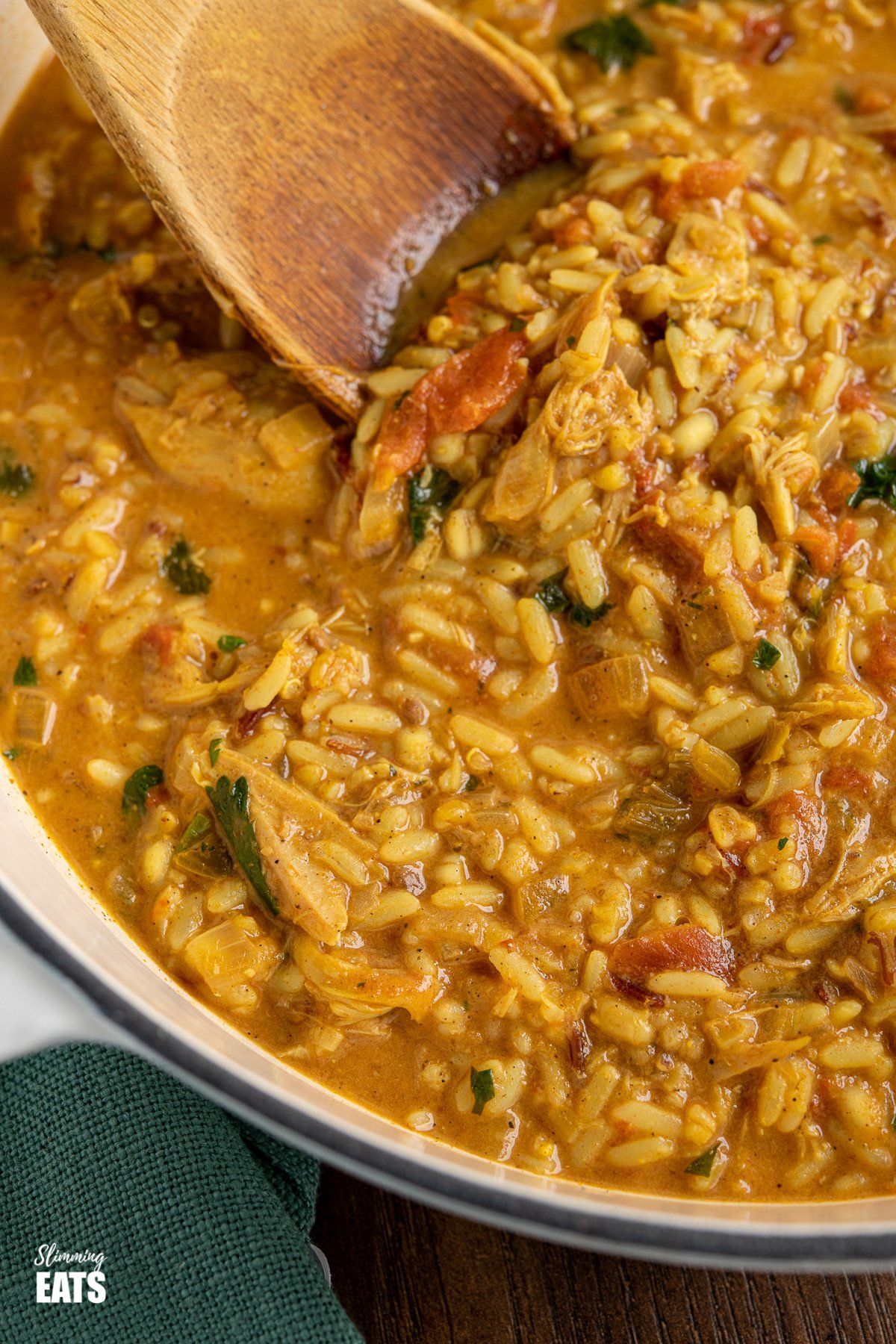 Coconut Chicken Rice Soup (from www.slimmingeats.com) - an easy to make filling bowl of soup that comes packed with flavour. You'll want to make this every week. #slimmingeats #weightwatchers #glutenfree #dairyfree #soup #chicken #rice close up of Coconut Chicken Rice Soup in cast iron pot