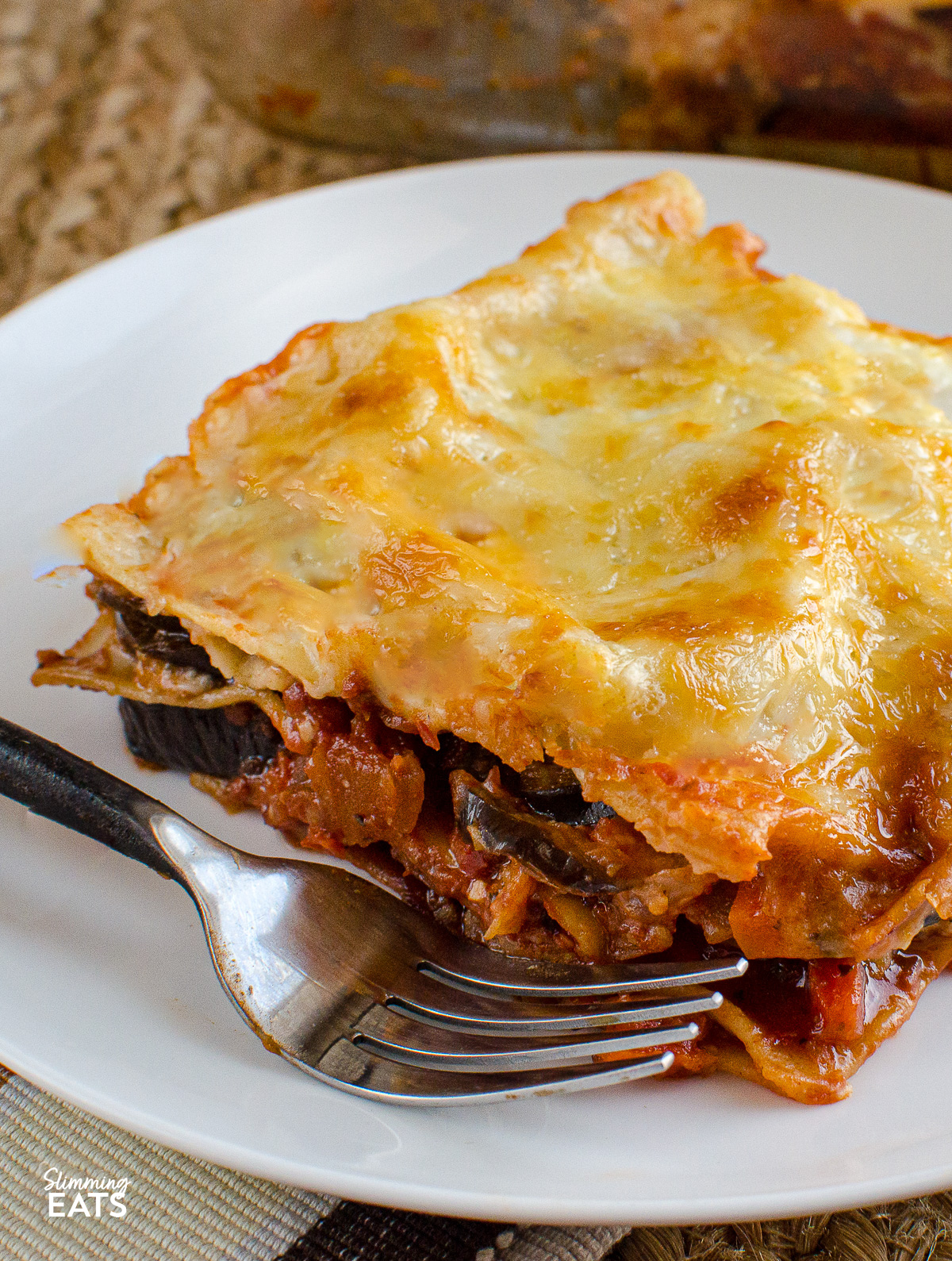 close up of Aubergine Lasagne on a white plate with fork