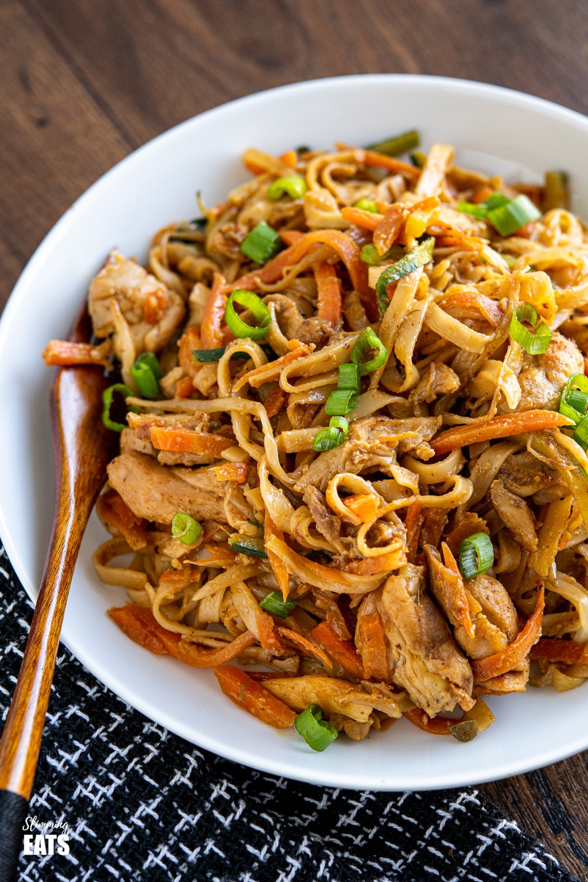 Easy Peanut Chicken Noodles (from www.slimmingeats.com) - a delicious simple noodle stir fry with chicken, vegetables and a peanut sauce. #slimmingeats #weightwatchers #peanut #chicken #noodles white bowl of easy peanut chicken noodles