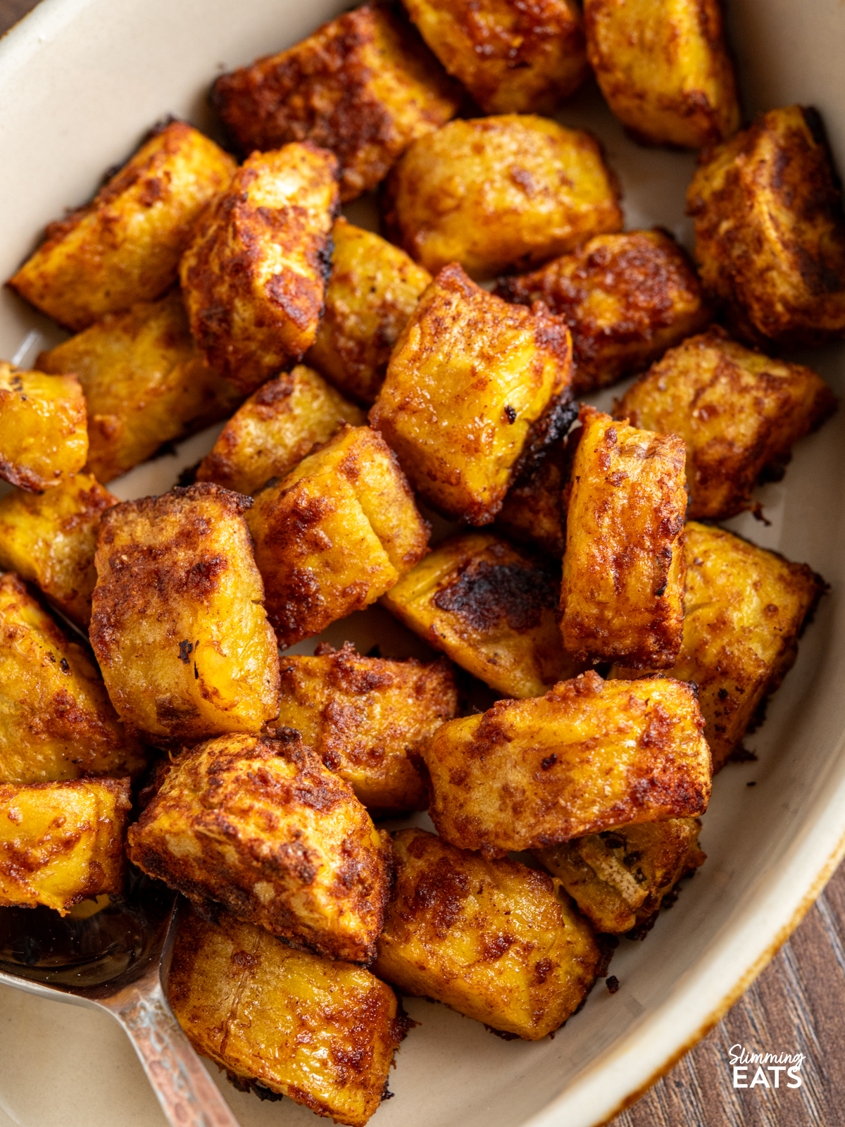 cooked seasoned sweet plantain in a oval brown and beige ceramic dish