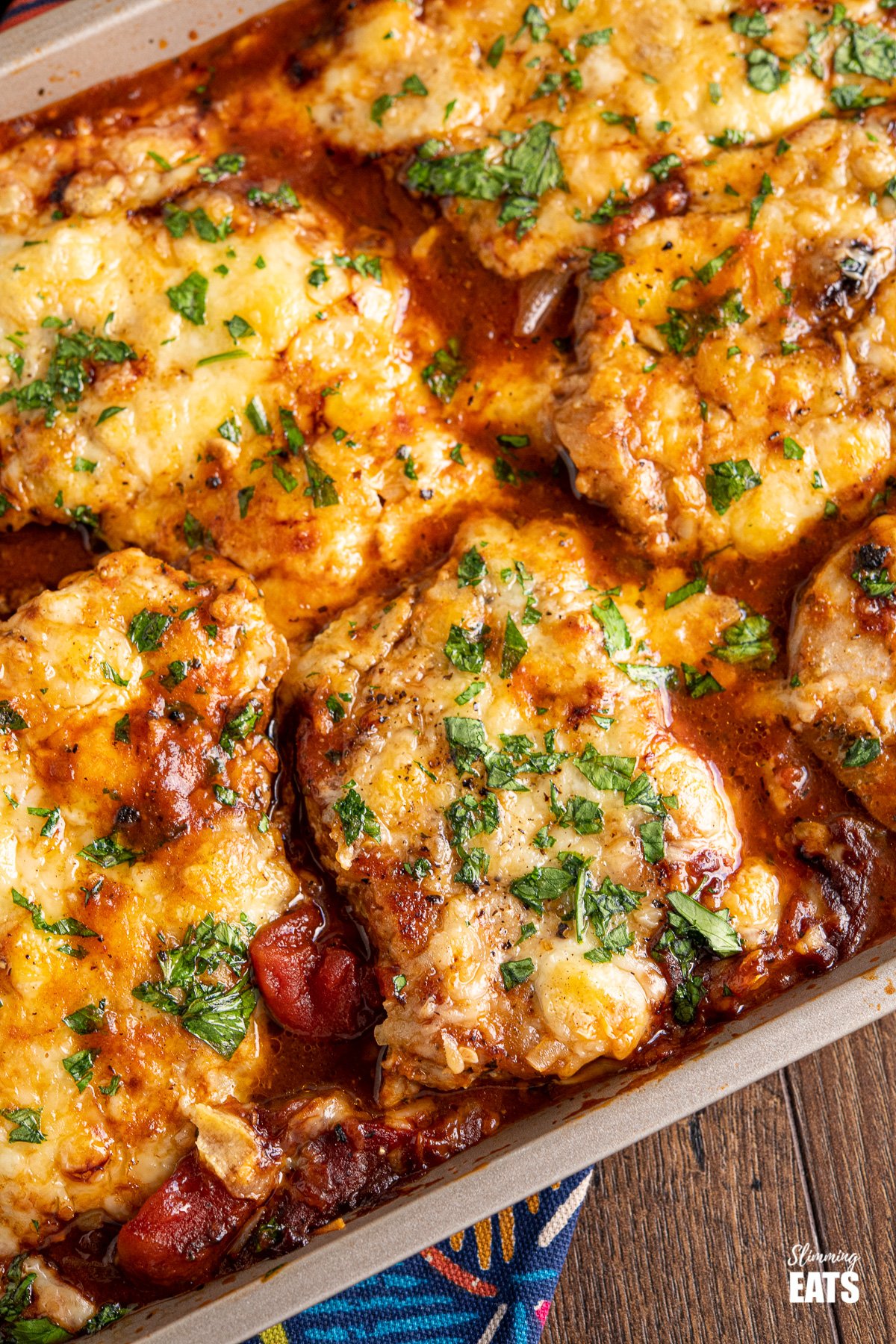 close up of Cheesy Topped Mediterranean Pork Loin Chops on baking tray