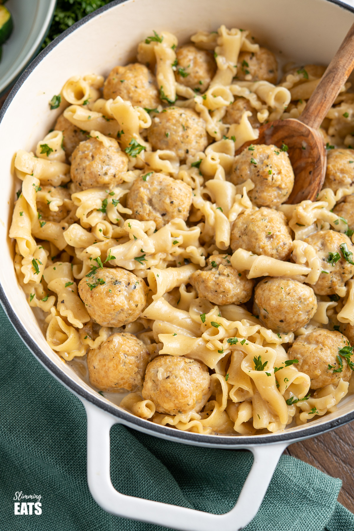 close up of One Pot Turkey Swedish Meatball Pasta in white cast iron pan with olive wood spoon 