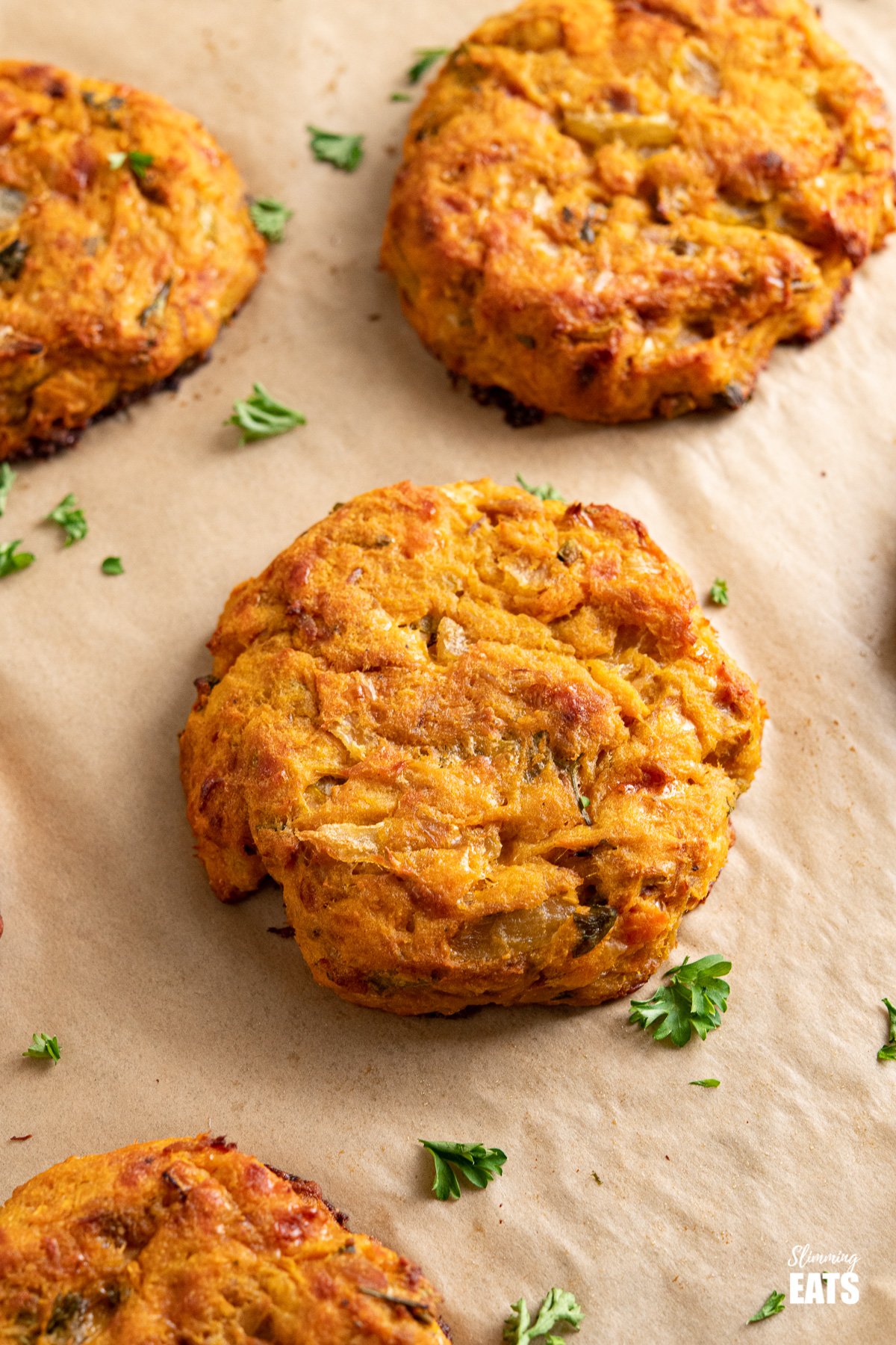 Tuna Sweet Potato Cheddar Patties - make these delicious patties with a few simple ingredients for a tasty lunch at home or on the go. #tuna #sweetpotato #slimmingeats #weightwatchers #glutenfree #cheddar close up of tuna sweet potato patties on parchment lined baking tray