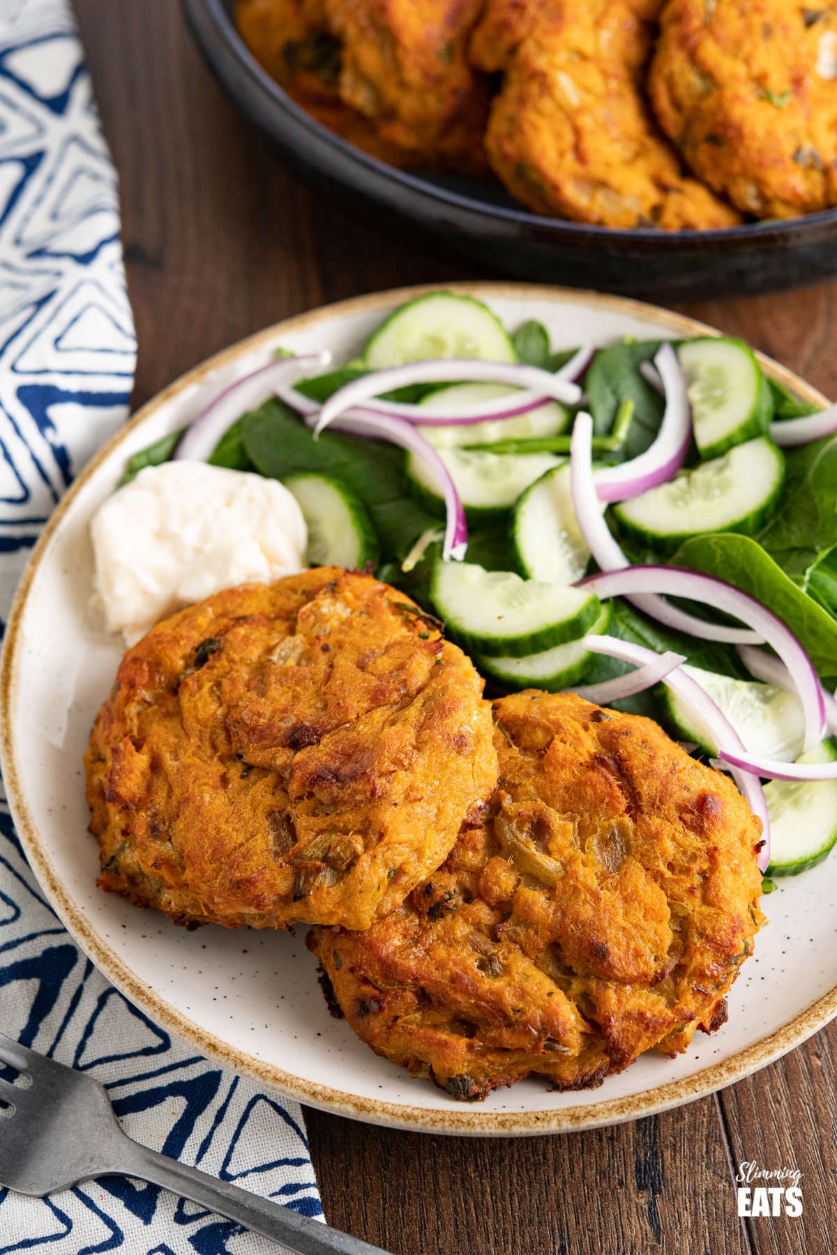 Tuna Sweet Potato Cheddar Patties on white plate with beige rim with salad and mayo