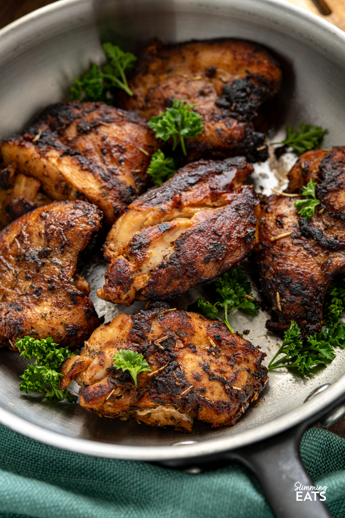 Seasoned Chicken with Rich Gravy - deliciously tender chicken thighs with seasoning and herbs paired with a delicious rich gravy. #glutenfree #dairyfree #chicken #gravy #slimmingeats #weightwatchers #smartpoints close up of seasoned chicken in frying pan with fresh parsley as a garnish