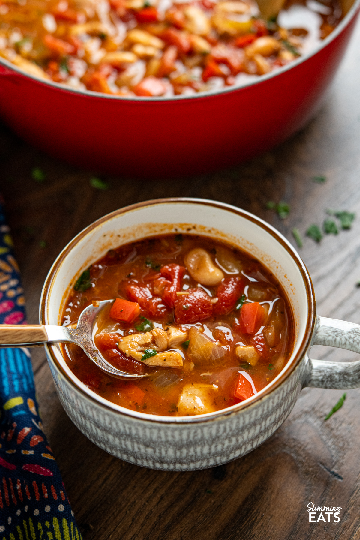 Chicken, Tomato and White Bean Soup - this hearty flavoursome soup is a complete meal in a bowl that the whole family will love. close up of chicken, bean and white bean soup in grey and brown mug with spoon