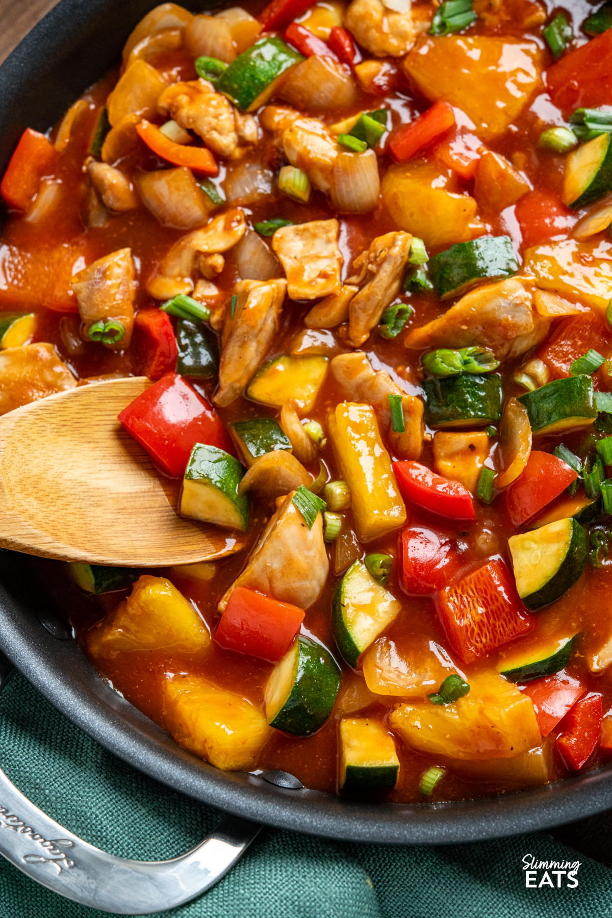 Sweet and Sour Chicken - a classic Chinese recipe you can make in your own home, with tender pieces of chicken thigh, fresh vegetables and pineapple in a delicious sauce. Dairy Free, Gluten Free, Slimming Eats and Weight Watchers friendly close up of chinese sweet and sour chicken in pan