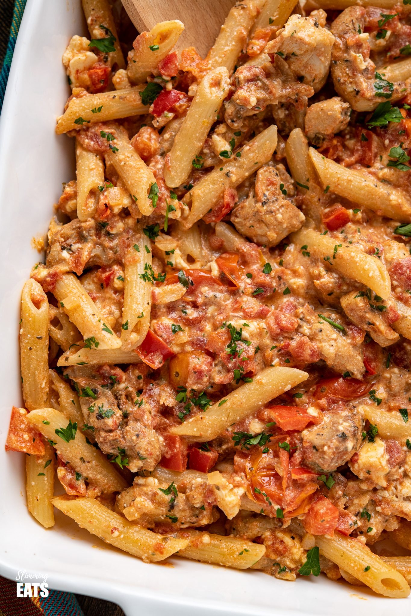 close up Baked feta pasta in white oven dish with chicken