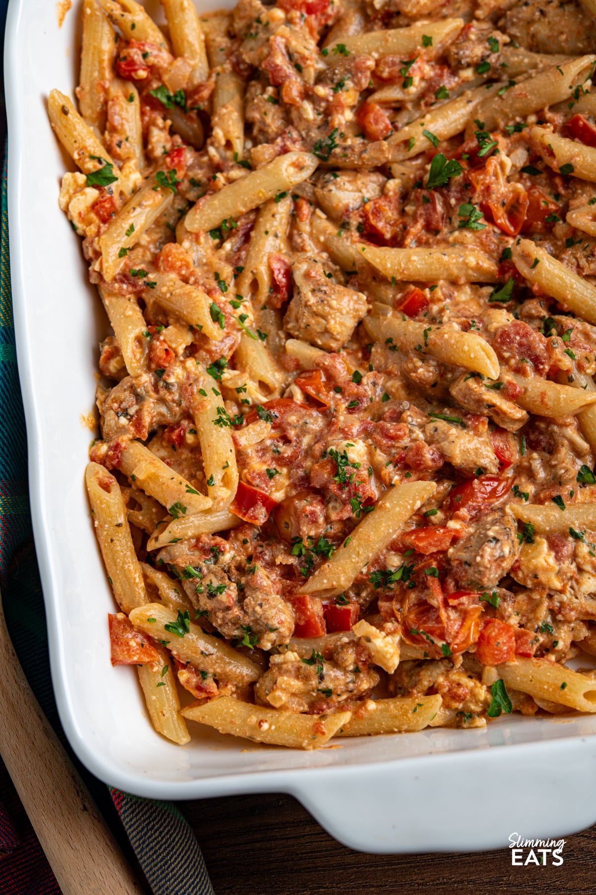 Baked Feta Pasta - a delicious variation of this popular recipe with tender chicken, tomatoes, red pepper, seasonings and penne pasta. Slimming Eats and Weight Watchers friendly close up of Baked feta pasta in white oven dish with chicken