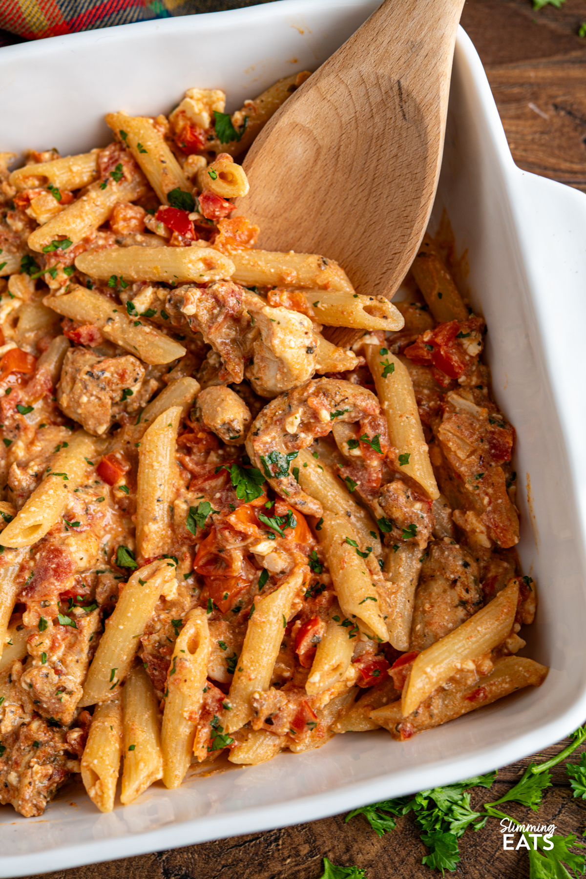 Baked Feta Pasta - a delicious variation of this popular recipe with tender chicken, tomatoes, red pepper, seasonings and penne pasta. Slimming Eats and Weight Watchers friendly close up Baked feta pasta in white oven dish with chicken