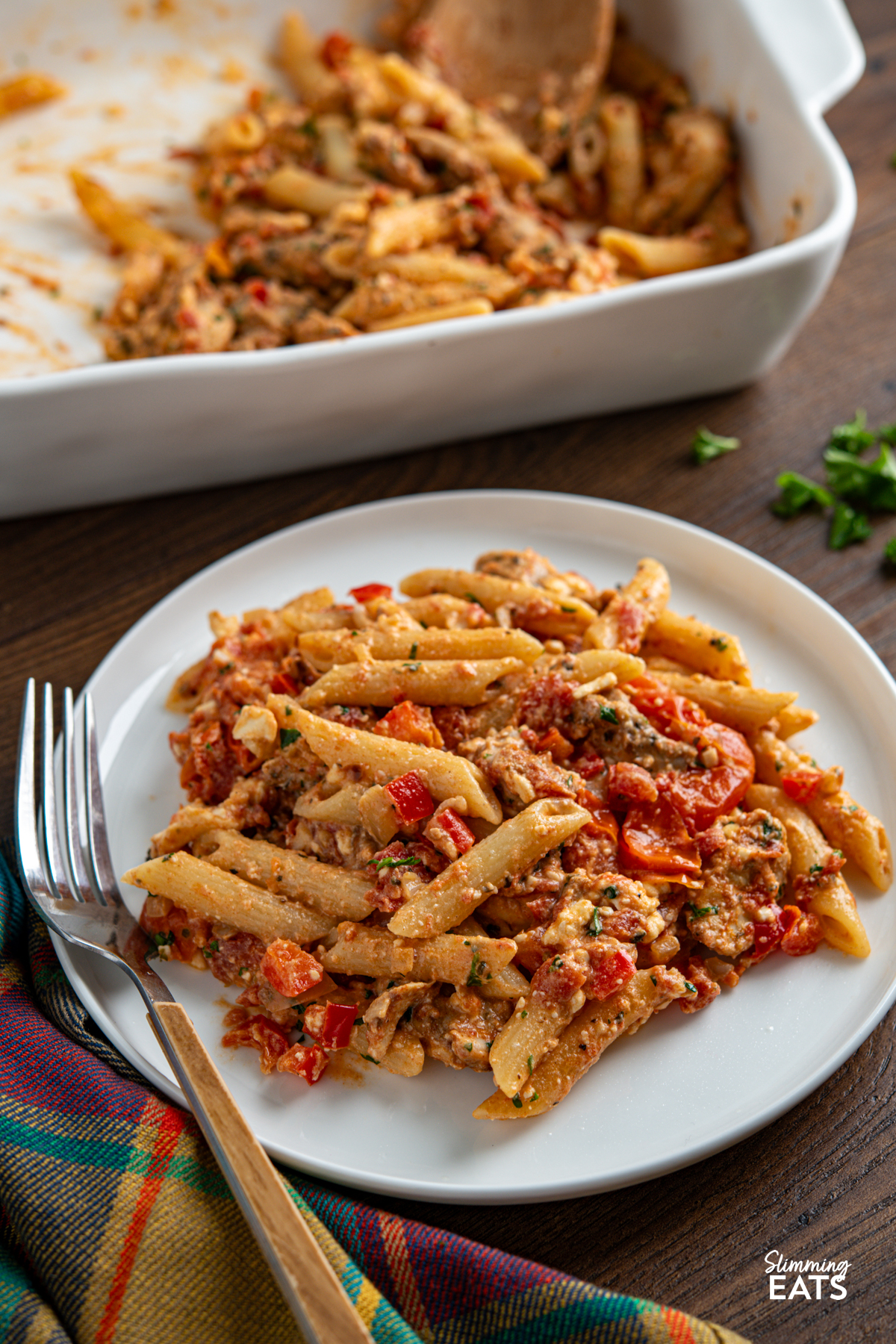 Baked Feta Pasta - a delicious variation of this popular recipe with tender chicken, tomatoes, red pepper, seasonings and penne pasta. Slimming Eats and Weight Watchers friendly close up Baked feta pasta in white oven dish with chicken