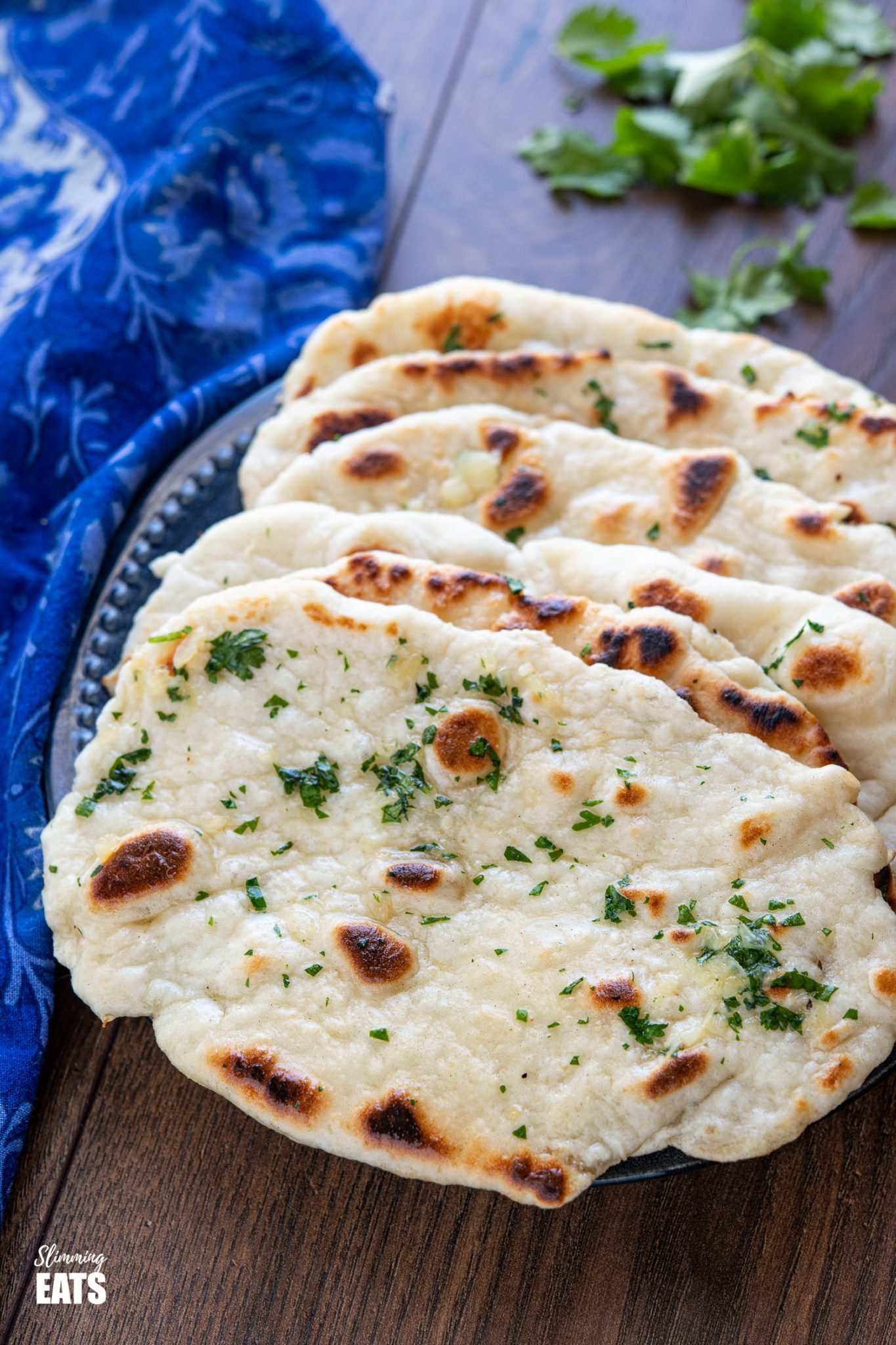 Garlic Greek Yoghurt Naan Bread on dark blue plate with scattered cilantro