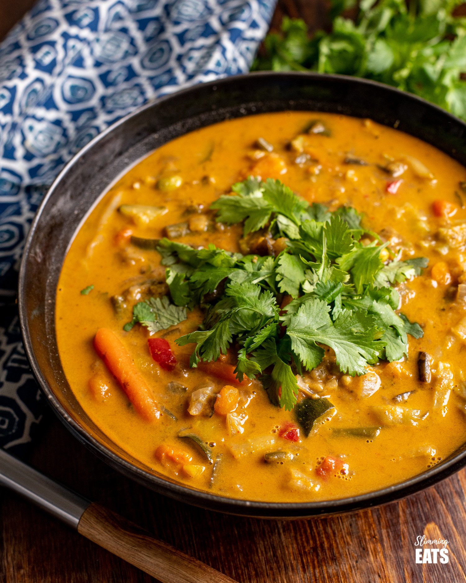 Thai Vegetable Soup in a black bowl topped with coriander