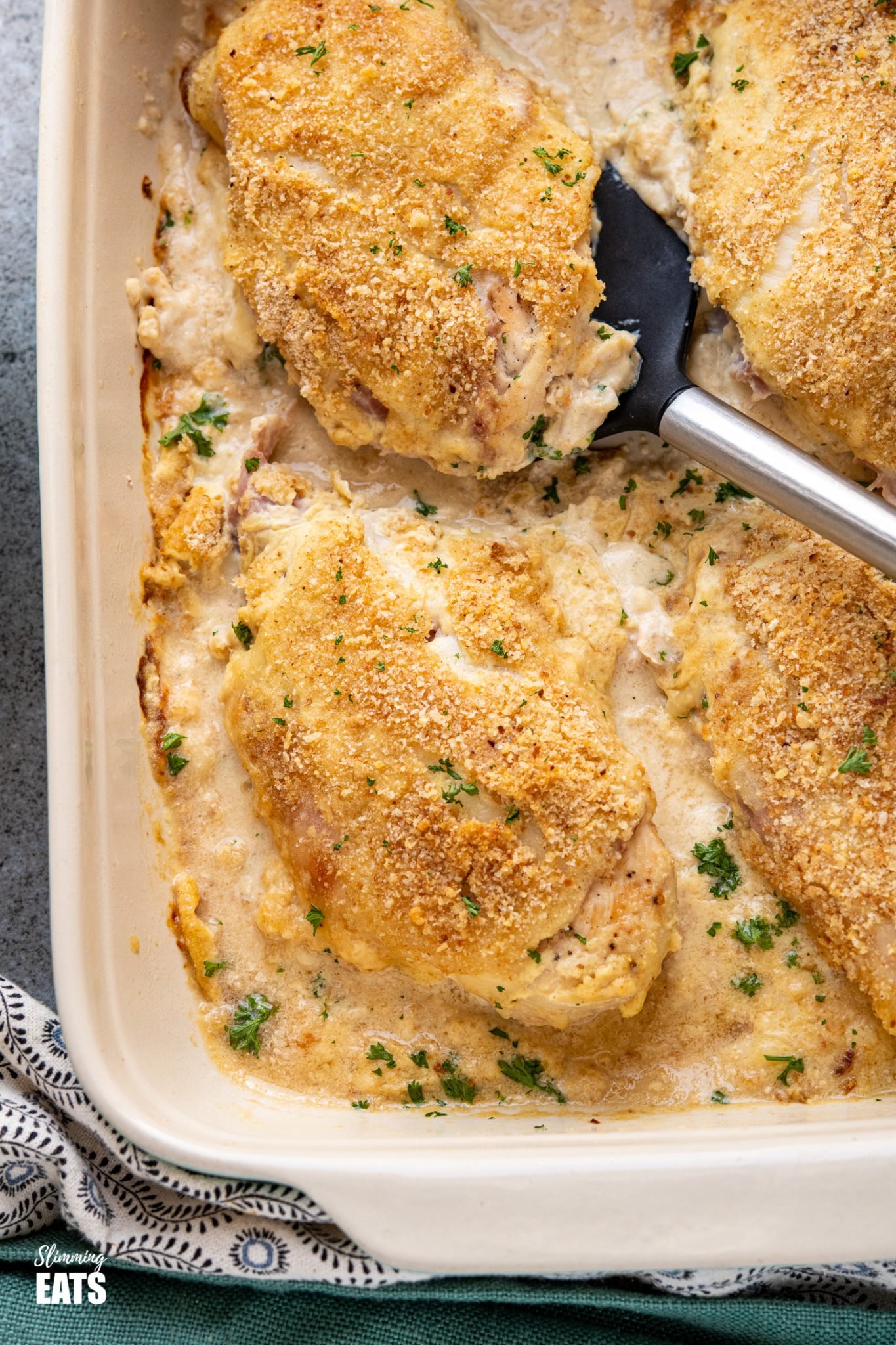 close up of Easy Chicken Cordon Bleu on spatula  in baking dish
