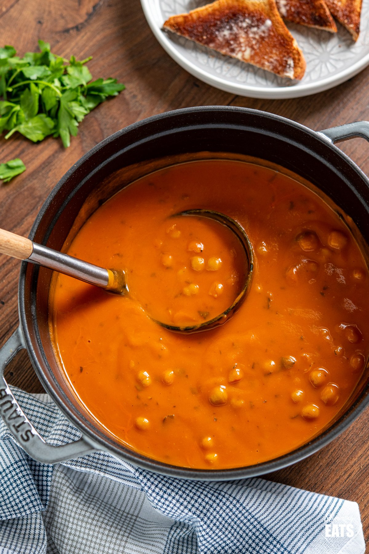 Chickpea and Tomato Soup in grey staub cast iron pan with soup spoon