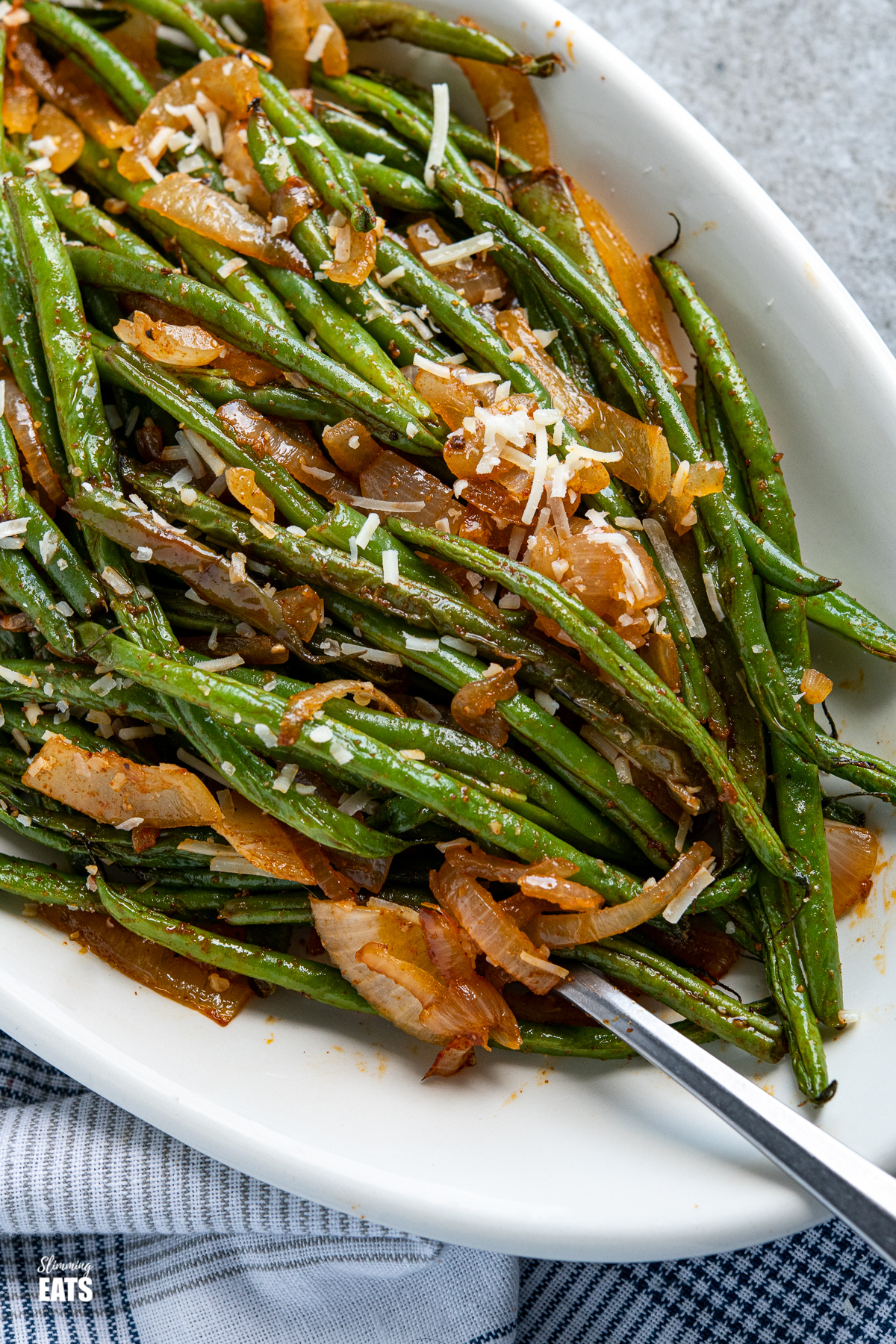 close up of Roasted Green Beans on a oval white plate