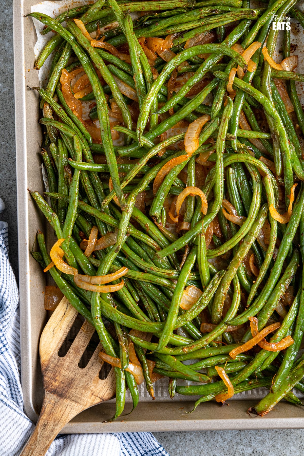 Roasted Green Beans on a baking tray with wooden spatula