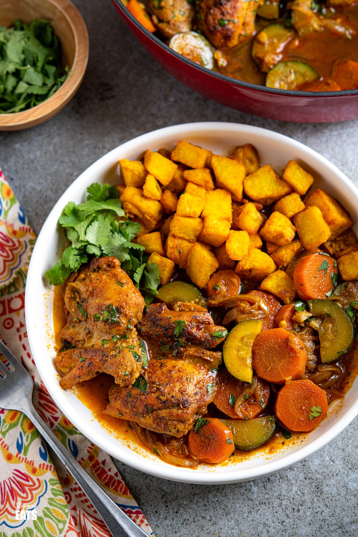 white dish with moroccan casserole and turmeric potatoes with cilantro