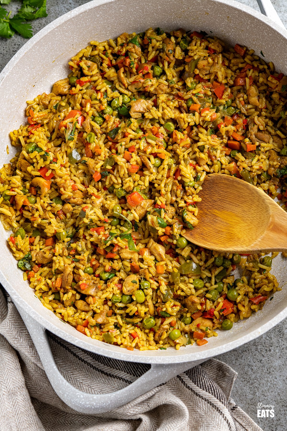 Coconut Chicken Curry Rice in frying pan with wooden spoon