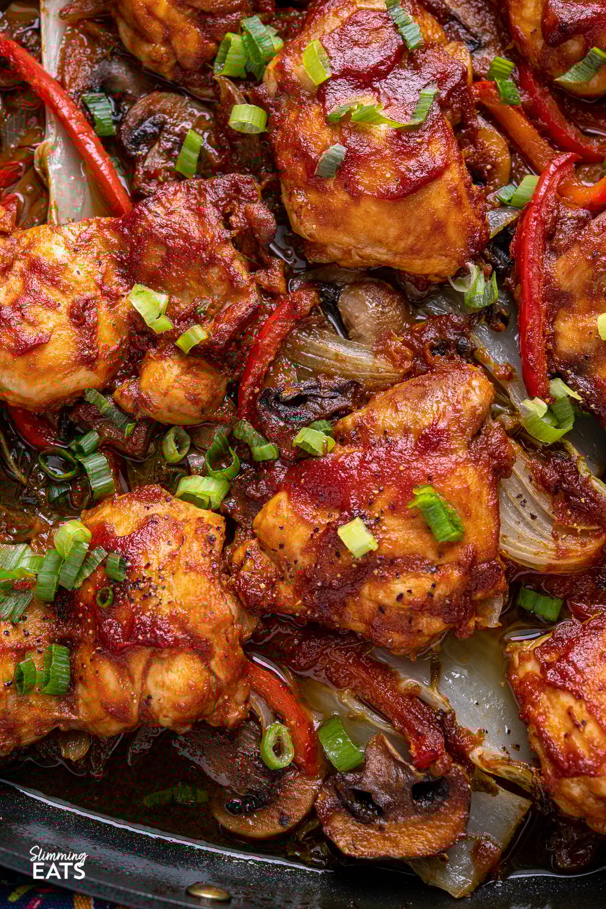 Sriracha Peach Chicken Bake - delicious tender chicken thighs with a spicy sriracha peach marinade baked over a bed of mixed vegetables. Gluten free, dairy free, Slimming Eats and Watchers friendly close up of Sriracha Peach Chicken Bake with vegetables in square All-Clad skillet
