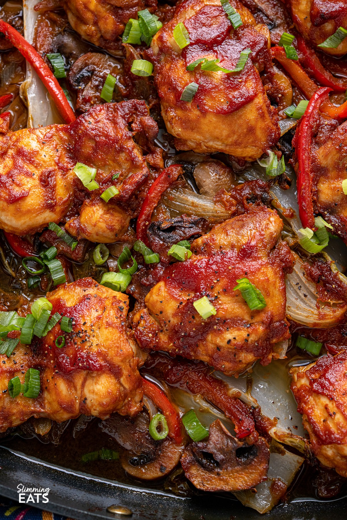 close up of Sriracha Peach Chicken Bake with vegetables in square All-Clad skillet 