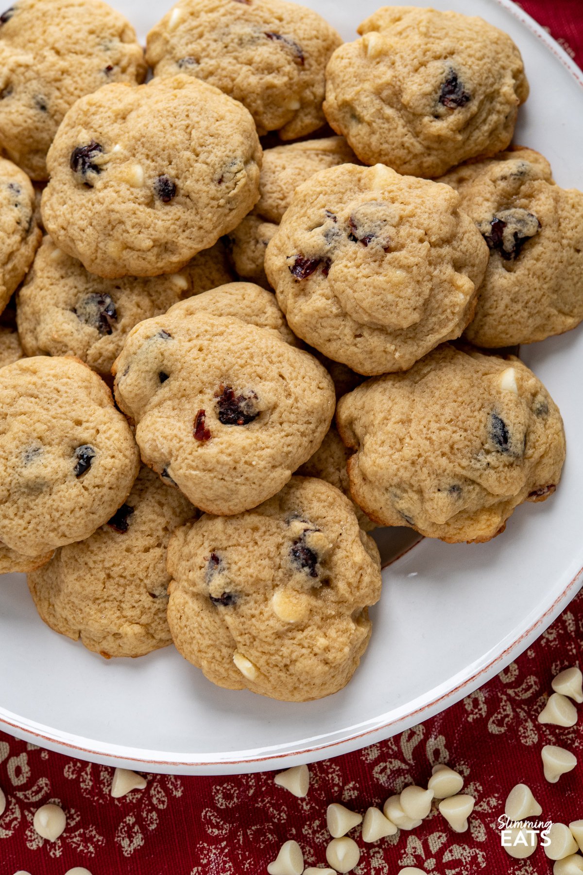 close up of pile of Cranberry White Chocolate Scone Cookies on a round white plate