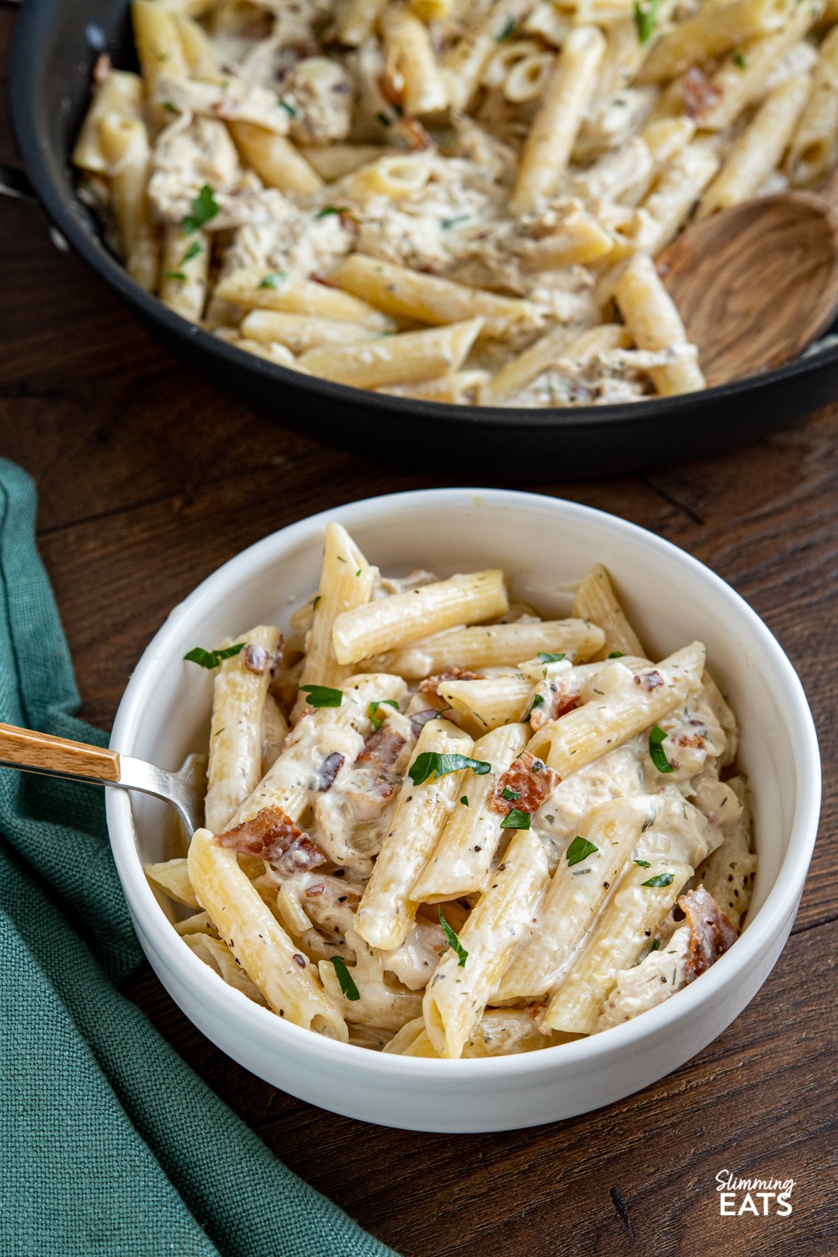 A pasta dish with the perfect combination - chicken and penne pasta in a creamy ranch flavoured pasta sauce all finished off with some smoky crispy bacon. What's not to love? What's not to love? Slimming Eats, Weight Watchers and Calorie Counting friendly recipes creamy chicken bacon ranch pasta in white bowl with fork