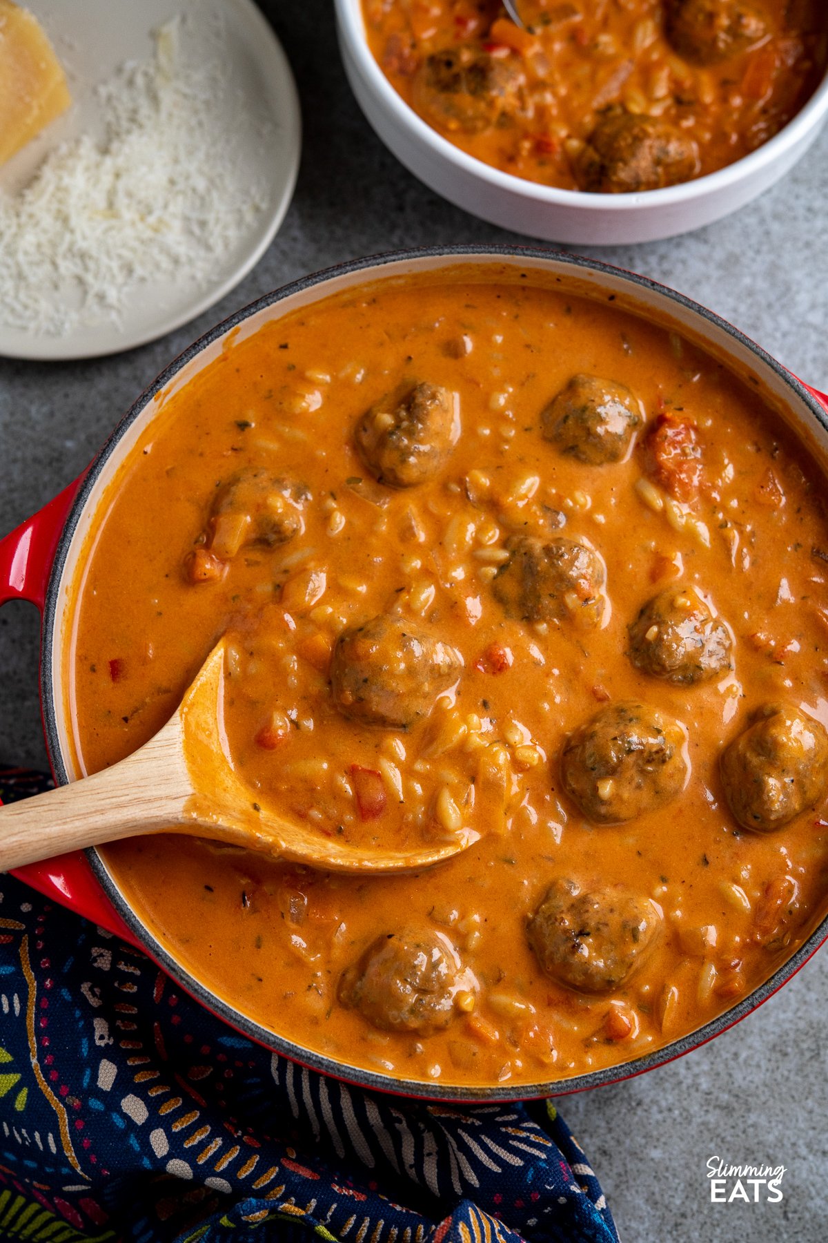 Flavoursome silky creamy tomato soup with orzo pasta and herby garlic chicken meatballs makes this a complete meal in a bowl that the whole family will love. Creamy Tomato Orzo Soup with Chicken Meatballs in a cerise le creuset casserole pot.