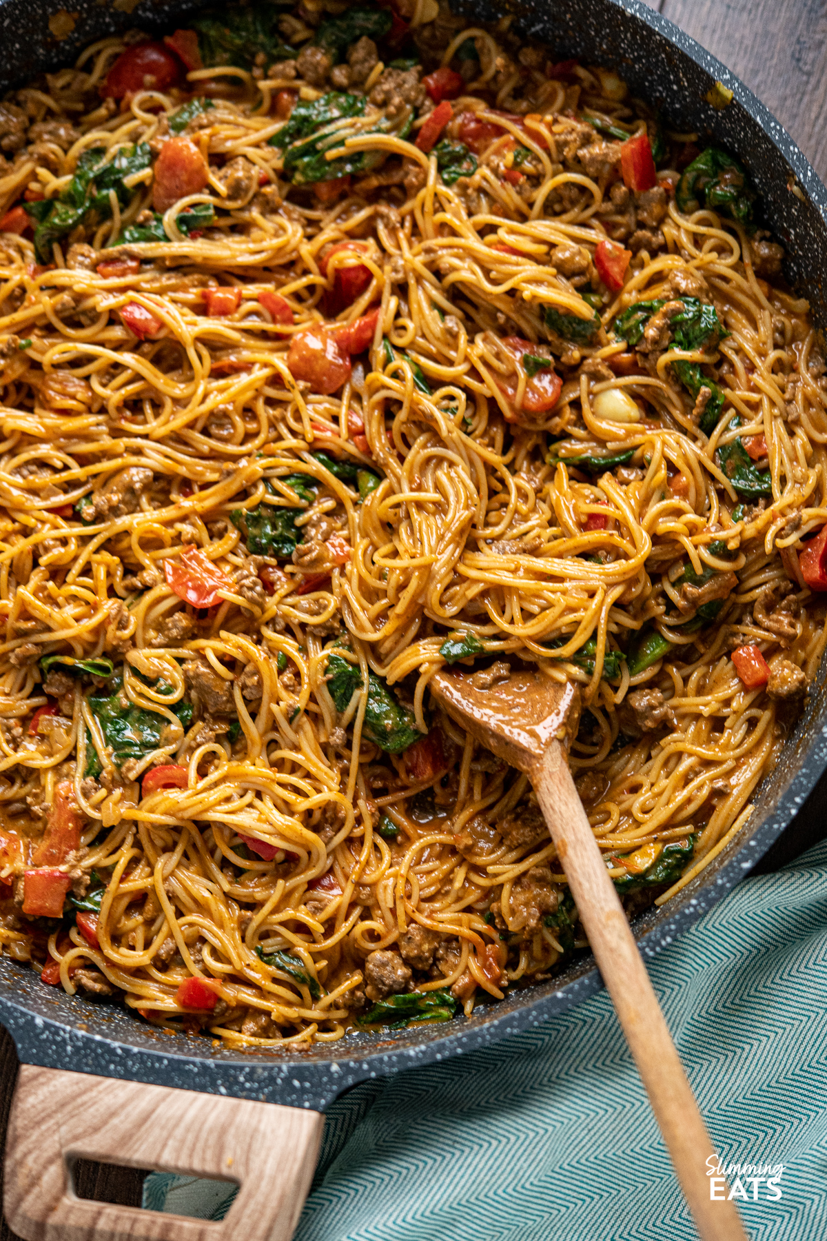 Creamy Harissa Beef Pasta in frying pan with wooden spoon