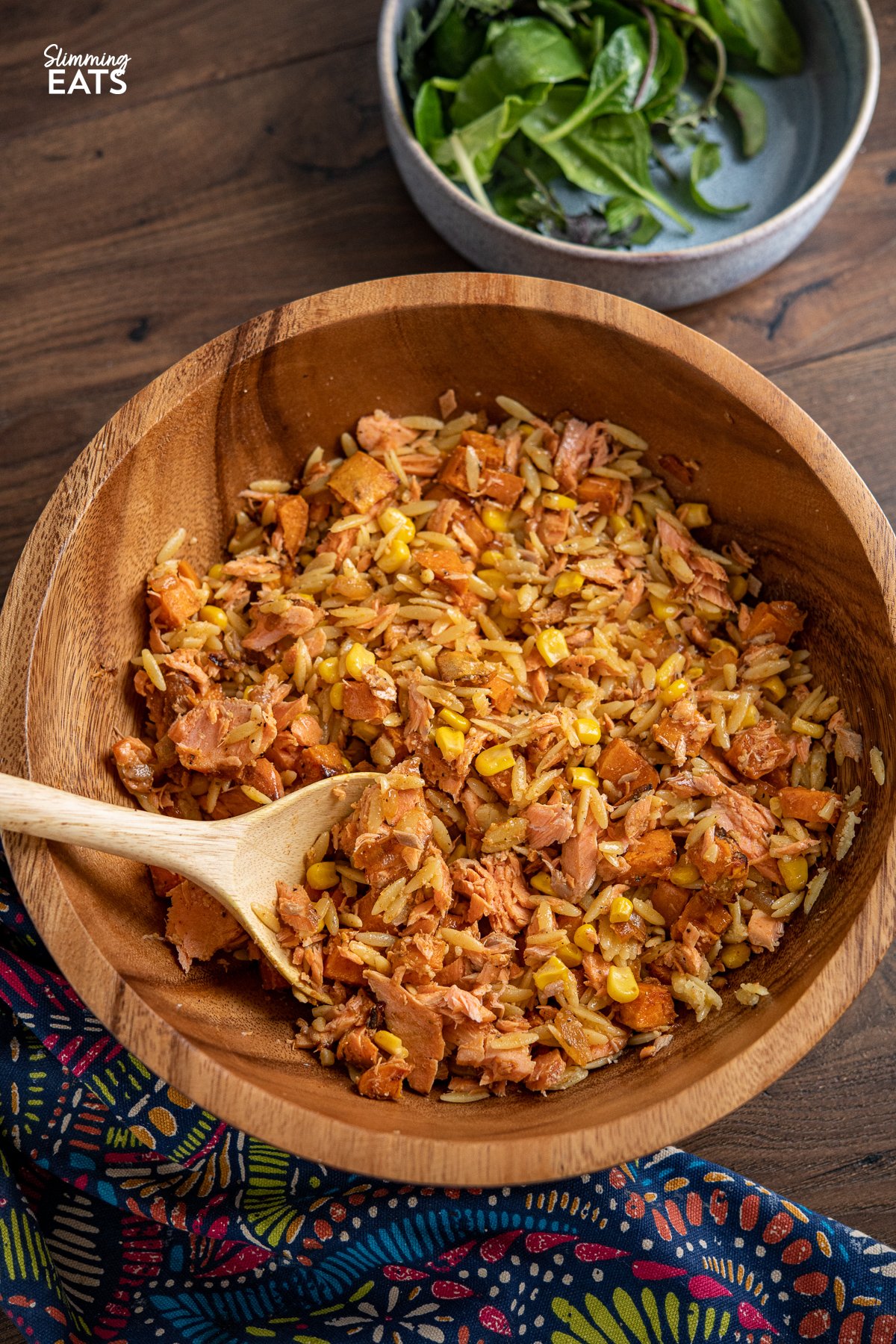 Salmon, Sweet Potato, Corn and Orzo Salad in a wooden bowl with spoon