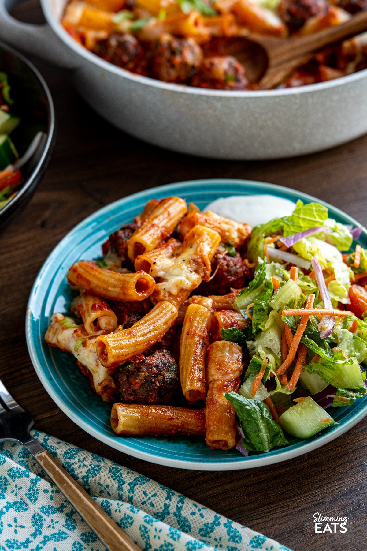 serving of Honey Buffalo Meatball Pasta Bake on turquoise plate with salad and ranch dressing