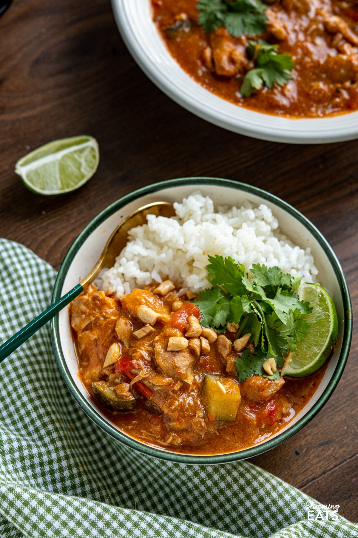 serving of Slow Cooker Thai Peanut Chicken Curry with white rice and chopped peanuts, coriander and lime wedge