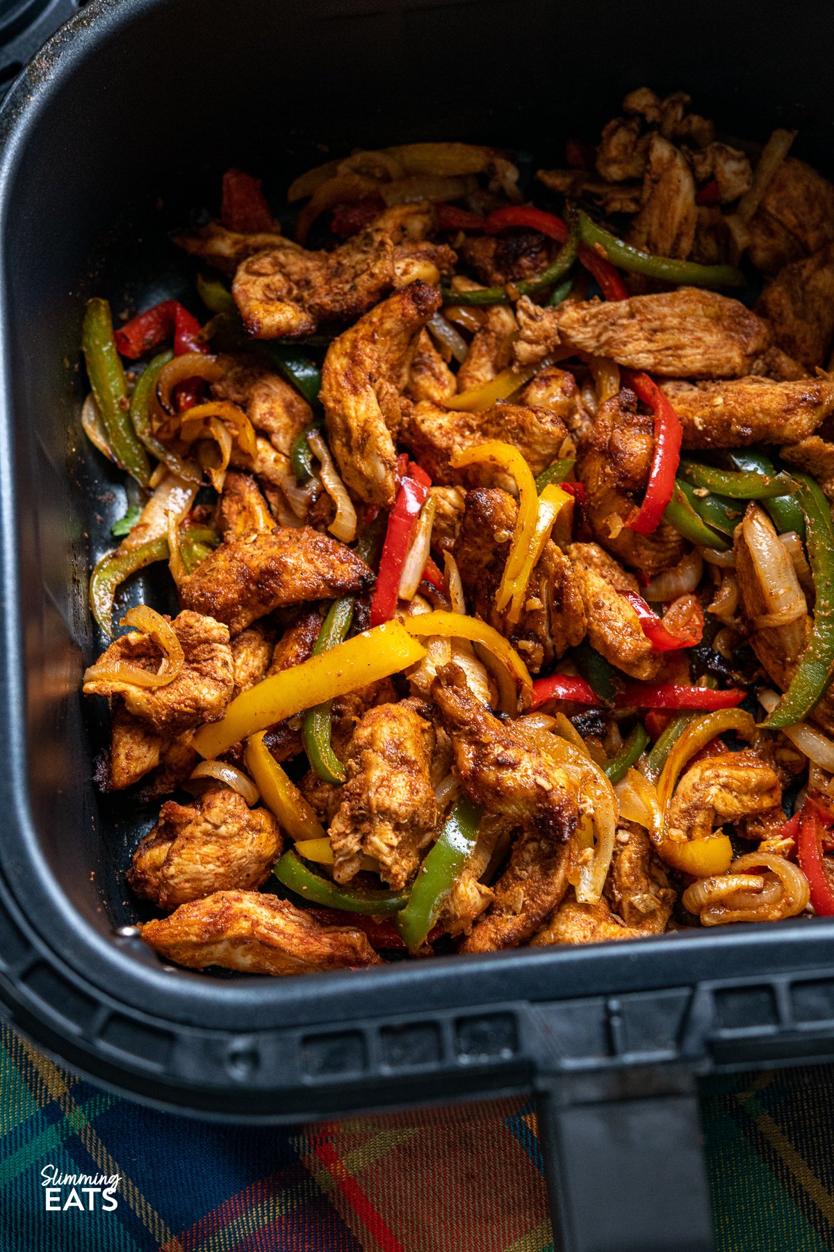 Are you looking for a quick and easy delicious dinner that is perfect for the whole family? Look no further than these simple Air Fryer Chicken Fajitas with tender chicken strips and mixed peppers and onion, all in the perfect homemade fajita seasoning blend. chicken fajitas in air fryer basket