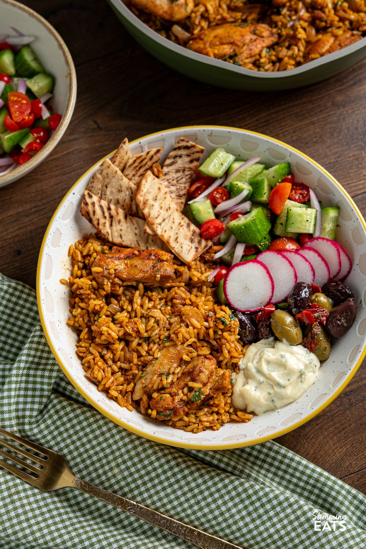 chicken shawarma and rice bowl with olives, cucumber, tomato, red onion and pita bread with garlic sauce