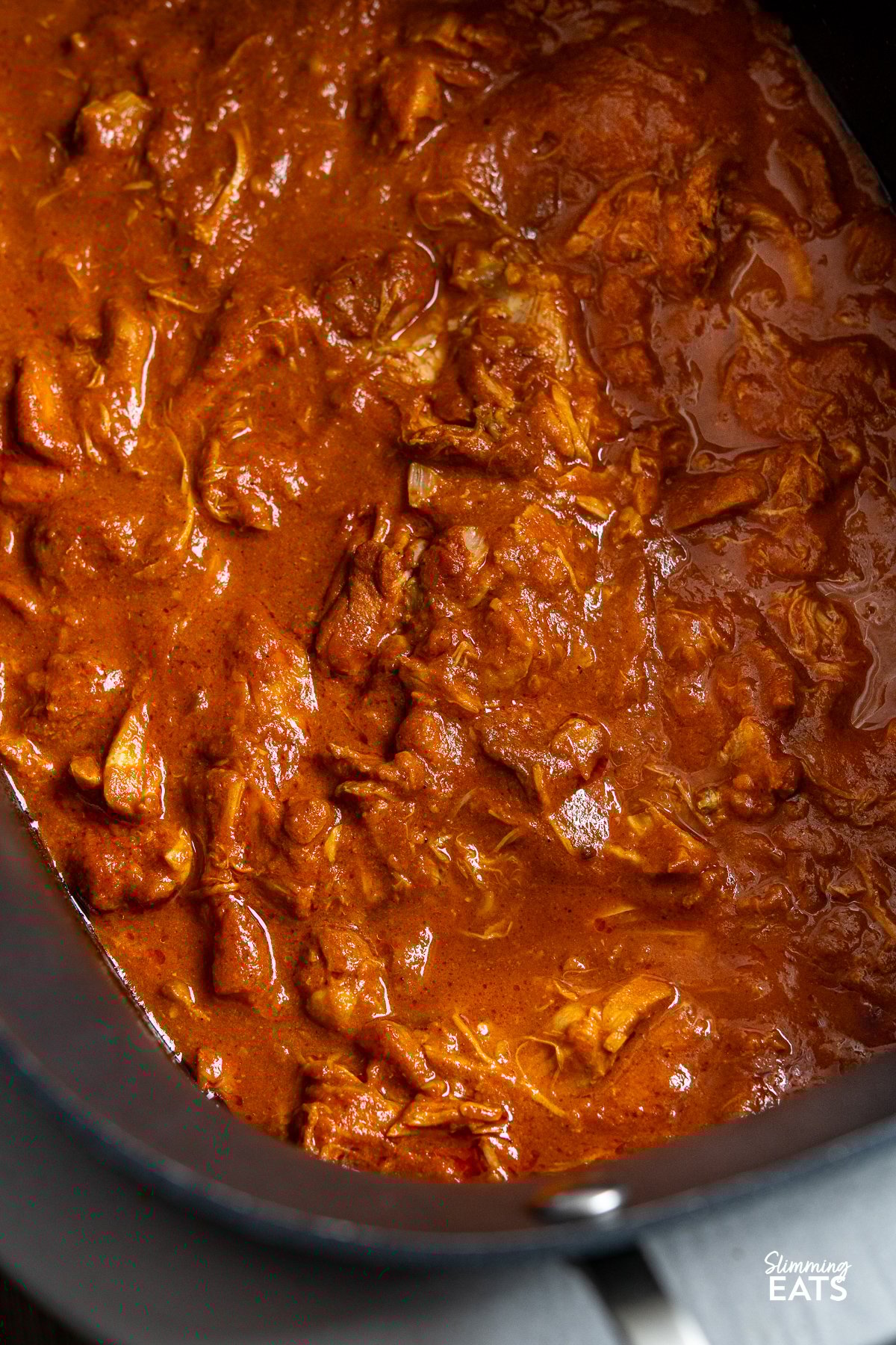 Enjoy the comforting flavours of this Easy Slow Cooker Tomato Chicken Curry. Tender chicken thighs cooked slowly in a lush tomato creamy sauce, spiced with the perfect mix of garlic, ginger, chilli and curry powder. This image features slow cooker tomato chicken curry in a slow cooker pot