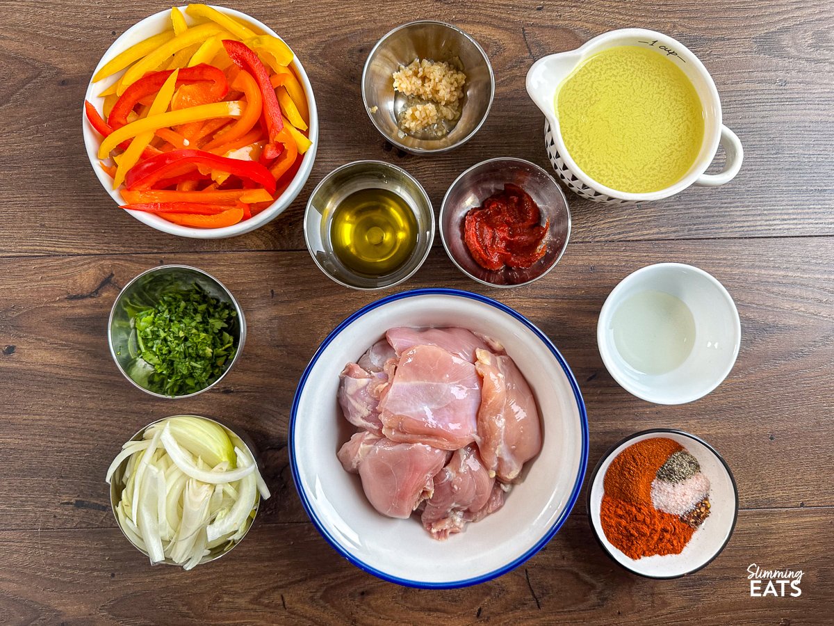 ingredients for sheet pan smoky paprika chicken thighs and peppers in bowls on a board. 