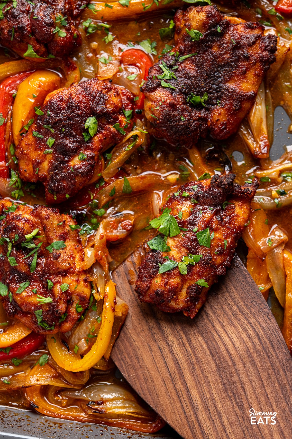 seasoned baked chicken thighs on a sheet pan with roasted juicy peppers with flavoursome broth. 