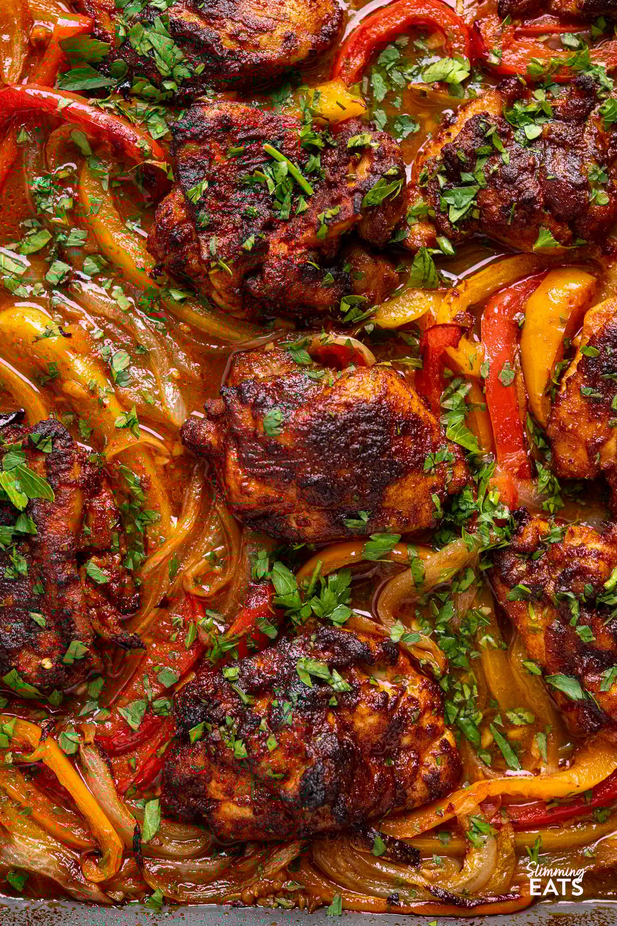 seasoned baked chicken thighs on a sheet pan with roasted juicy peppers with flavoursome broth. 
