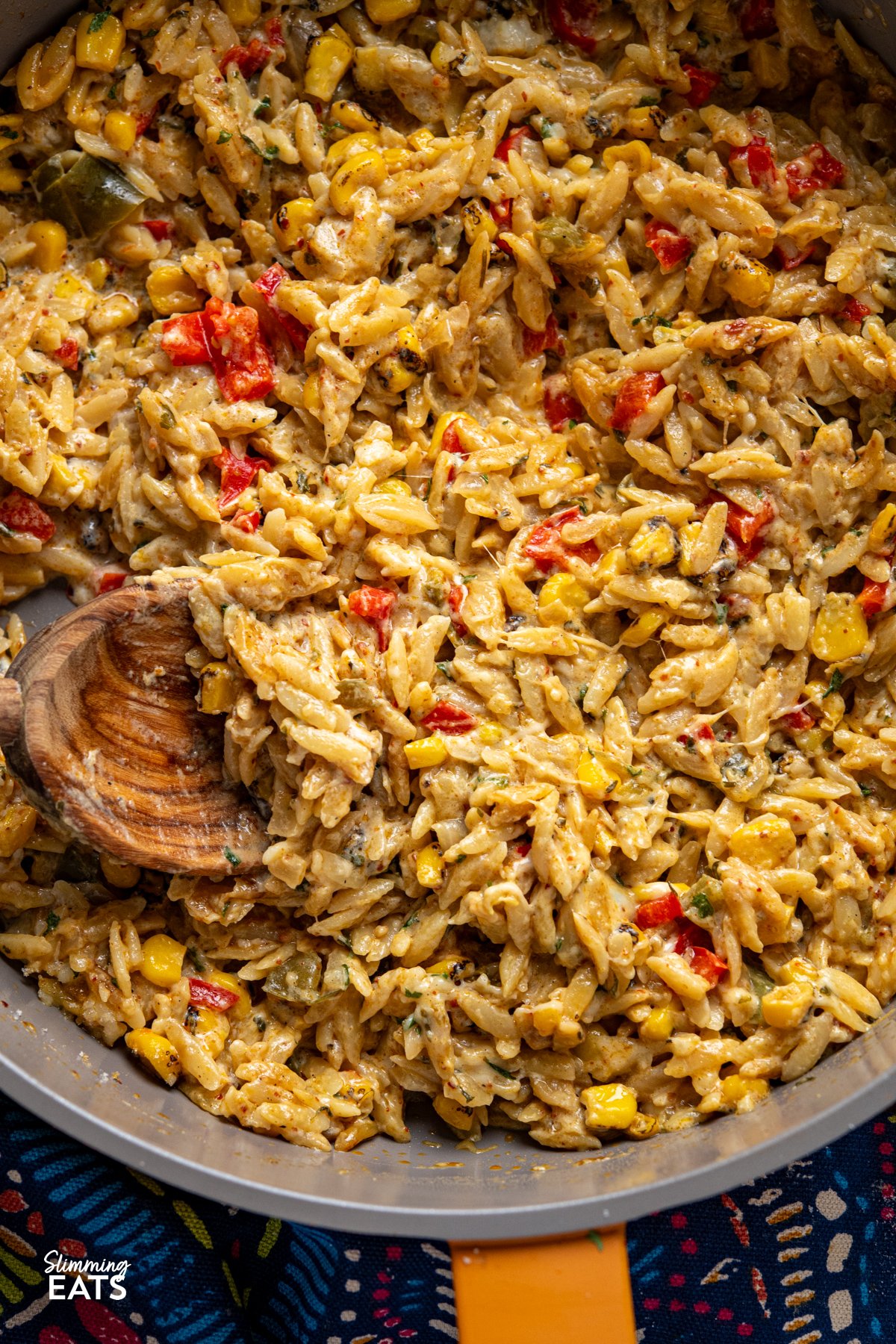 This One Pot Creamy Cheesy Spicy Corn Orzo is the kind of throw-together dinner that tastes like you put in way more effort than you actually did. It starts with smoky charred corn—bringing a hit of sweetness and depth—then builds into a cosy, creamy dish with just enough heat to keep things interesting. Think mac and cheese meets chilli-spiked corn chowder. close up of One Pot Creamy Cheesy Spicy Corn Orzo served in a yellow non-stick skillet