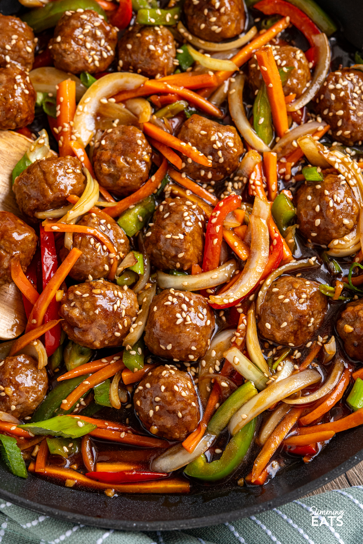 This Easy Asian Meatball Stir Fry is a quick and flavourful weeknight dinner that brings tender meatballs and vibrant vegetables together in a glossy savoury sweet sauce. close up of Easy Asian Meatball Stir Fry in black frying pan