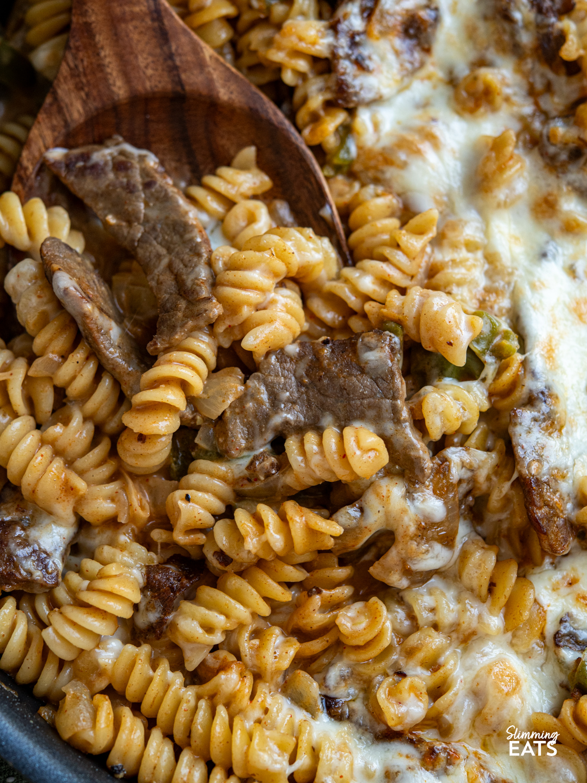 This One Pot Philly Cheesesteak Pasta is a creamy, cheesy twist on the classic sandwich, with tender beef, peppers, and onions all cooked together for an easy, comforting meal. close up of One Pot Philly Cheesesteak Pasta in non stick pan