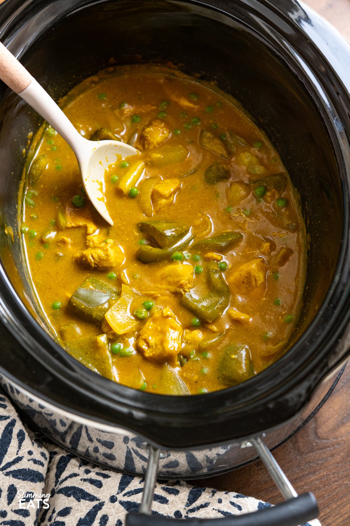 Slow Cooker Chinese Chicken Curry in slow cooker with serving spoon.