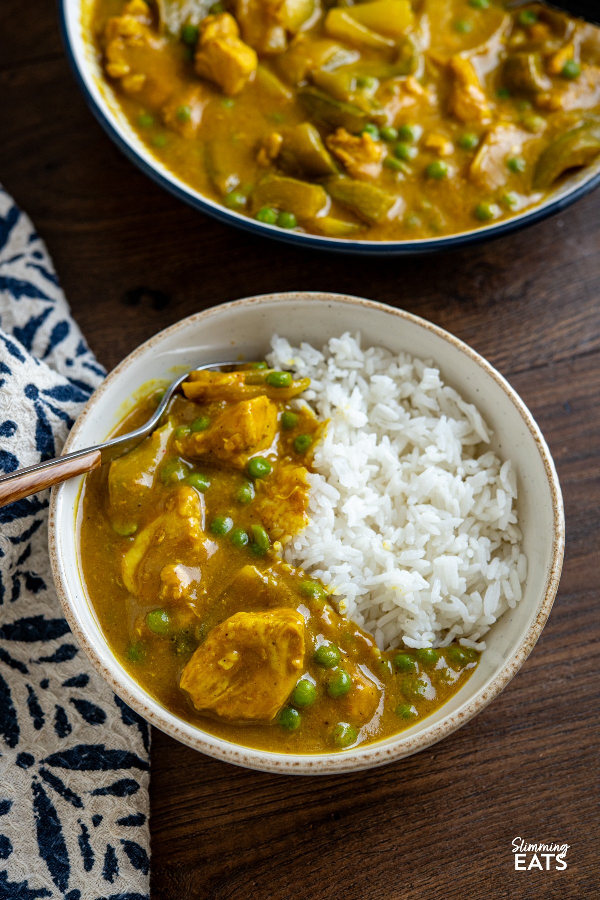 Slow Cooker Chinese Chicken Curry in a bowl with jasmine rice, large bowl showing remaining curry.