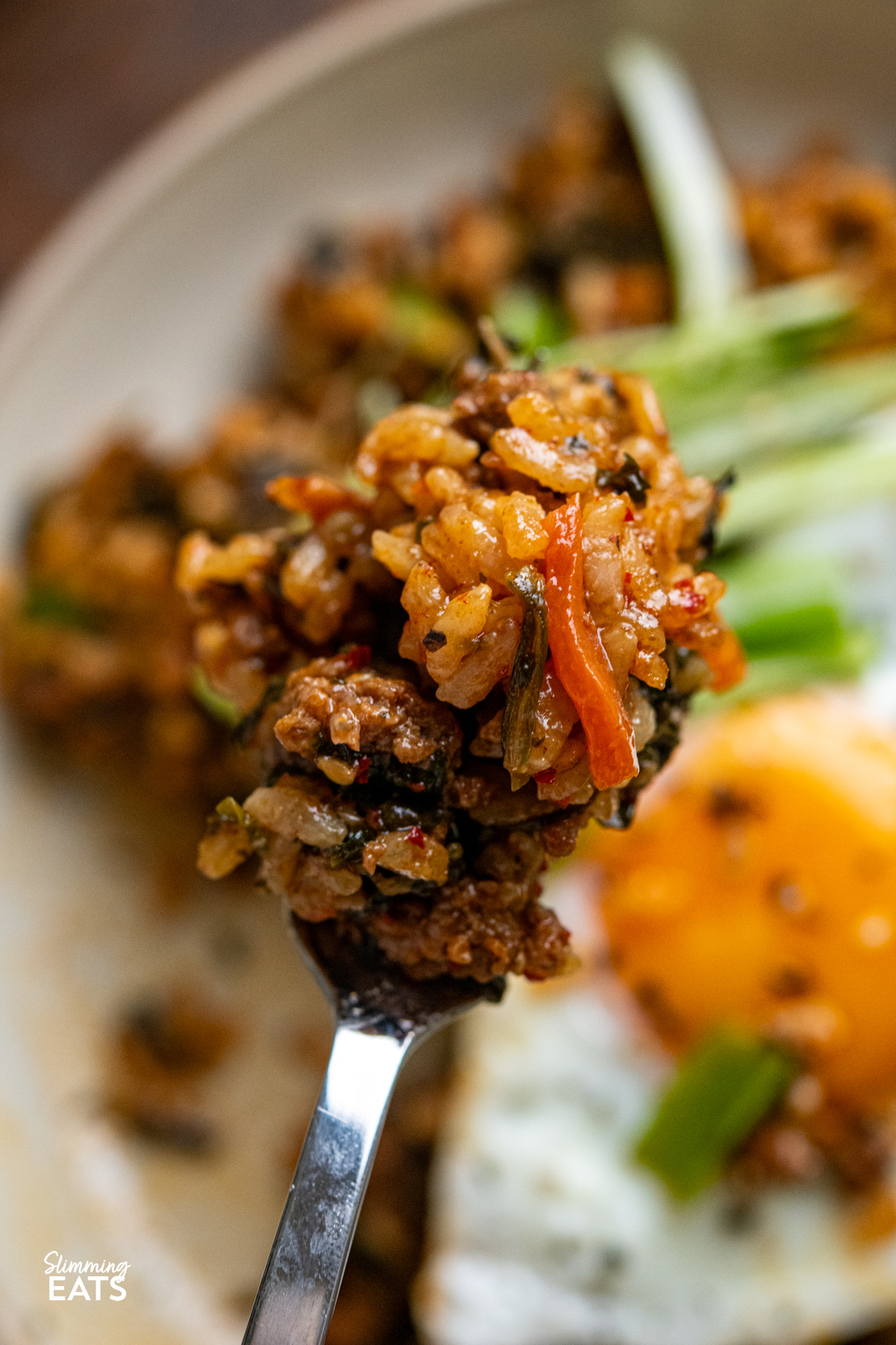 Enjoy the rich, savoury comfort of this Slow Cooker Korean Beef with Spinach and Rice. Ground beef simmers with garlic, ginger, and a sauce where gochujang is the star, alongside spinach and rice for a complete, flavour packed meal. fork scooping up a mouthful of Slow Cooker Korean Beef Spinach Rice from serving in a bowl.