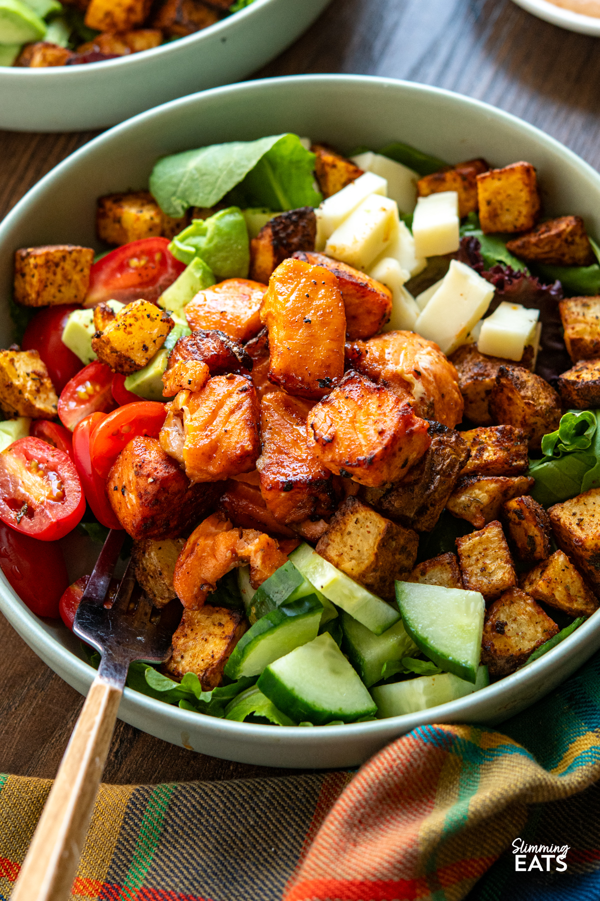 close up of Air Fryer Hot Honey Salmon Bowls  featuring salmon, potato, salad, avocado and gouda 